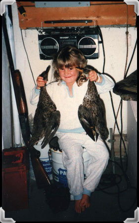 Girl holding two dead ducks.