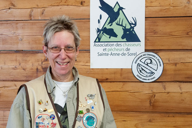 Carole Deschenaux in front of the old and new logos of the Association des chasseurs et pêcheurs de Sainte-Anne-de-Sorel