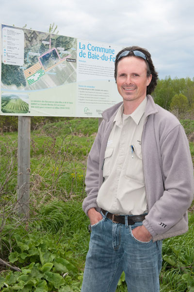  A man standing in front of an information panel showing an aerial view of the site.